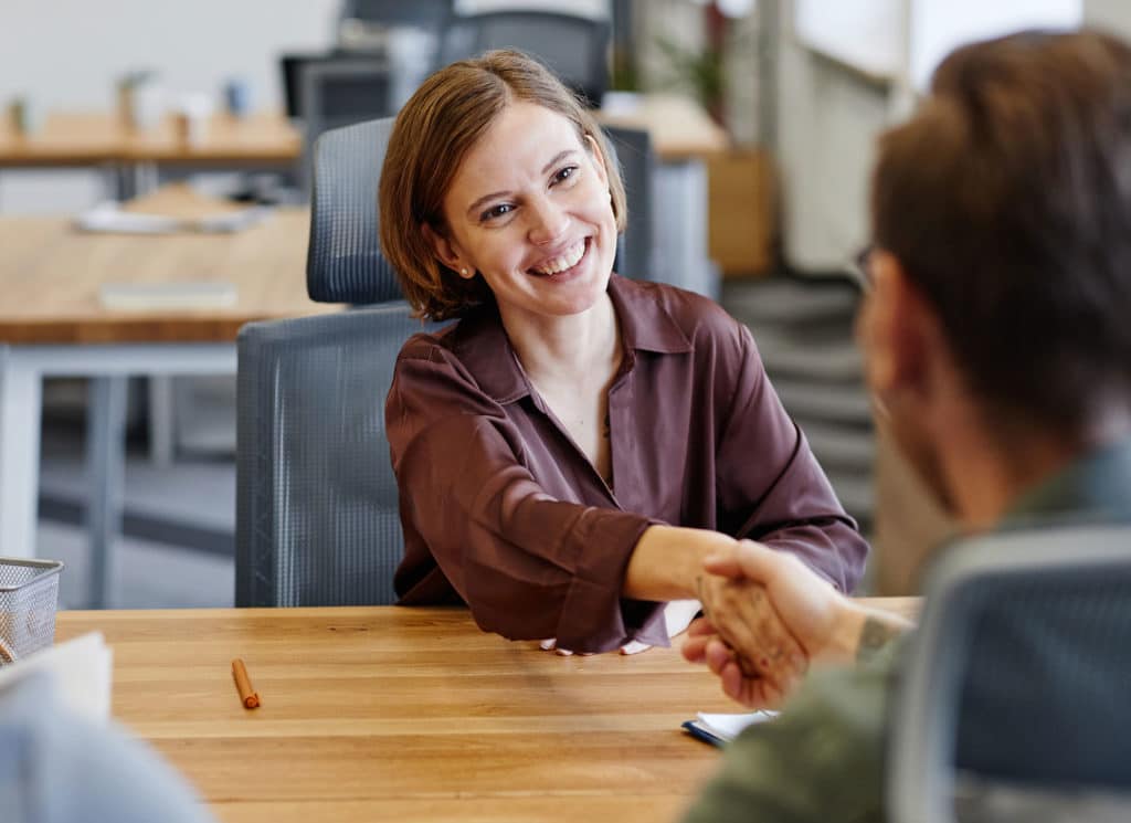 Young woman shaking hands with HR manager at job interview